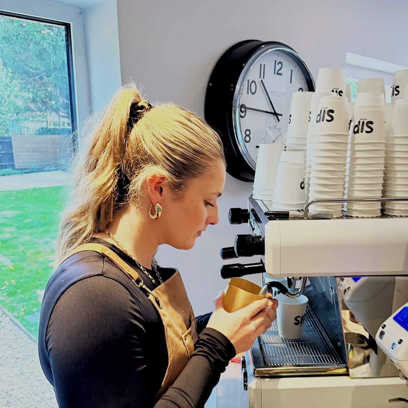 A Sip Social barista steaming milk at the espresso machine