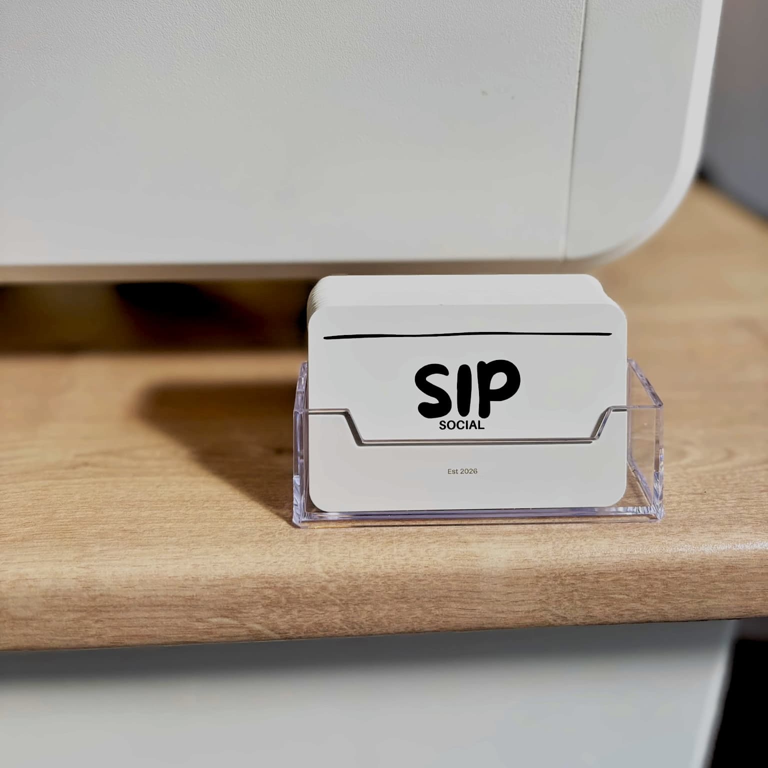 Branded Sip Social cards in a holder on the coffee cart