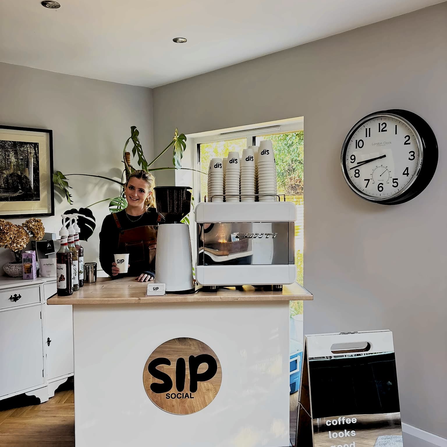 Barista serving coffee from behind the Sip Social cart